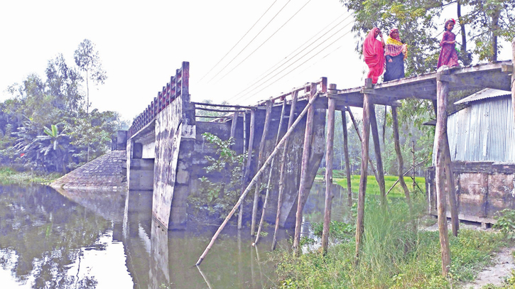 Flood-damaged bridge over canal lies unrepaired